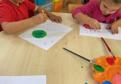 Dzieci malują za pomocą pędzli małe kropki oraz wypełniają kontur wielkiej kropki wybranym kolorem farby