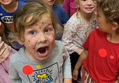 Uśmiechnięte dzieci z namalowanymi piegami na twarzy w wybranych przez Nie kolorach