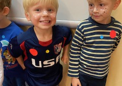 Uśmiechnięte dzieci z namalowanymi piegami na twarzy w wybranych przez Nie kolorach