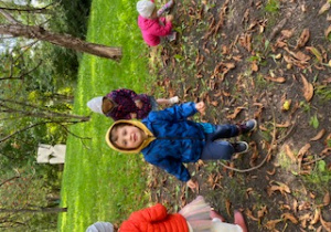 Dzieci zbierają kasztany do wiklinowego kosza