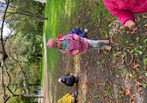 Dzieci zbierają kasztany do wiklinowego kosza