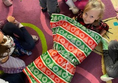 Zabawa grupowa "pakujemy prezent" -próby zapakowania dziecka przez koleżanki i kolegów w papier do pakowania prezentów