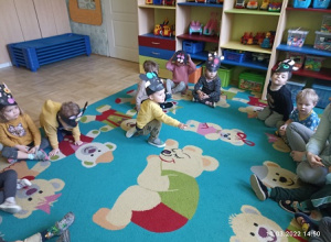 Dzieci w opaska na głowie bawią się na dywanie