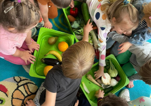 Dzieci segregujące warzywa i owoce