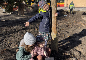 Dziewczynki przy drzewie używające łopaty