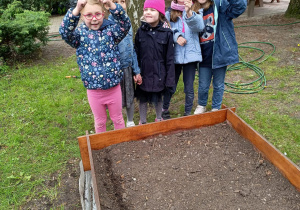 Dziewczynki podczas sadzenia roślin w ogrodzie